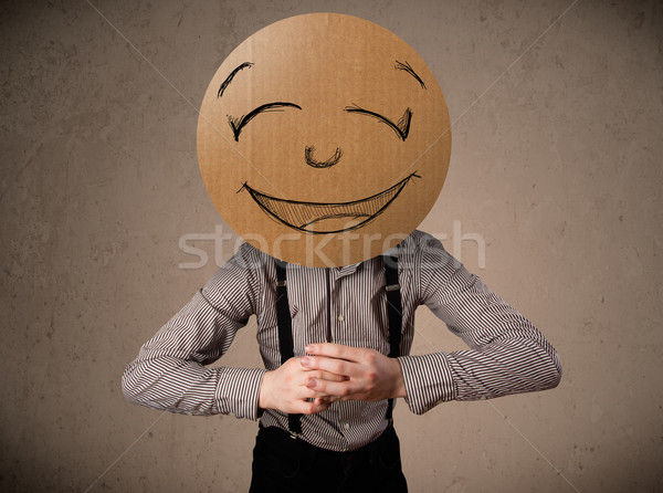 Businessman holding a smiley face board Stock photo © ra2studio