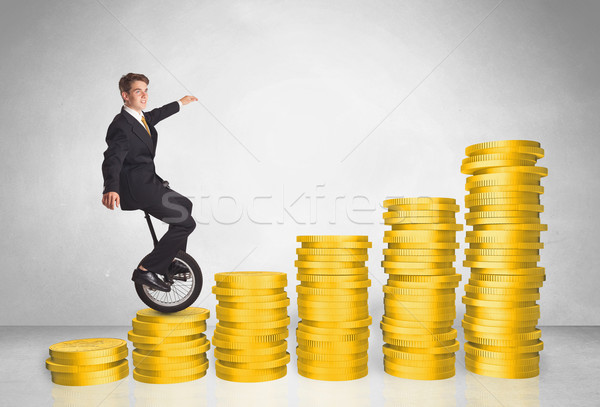 Stock photo: Business man riding monocycle up on coin graph