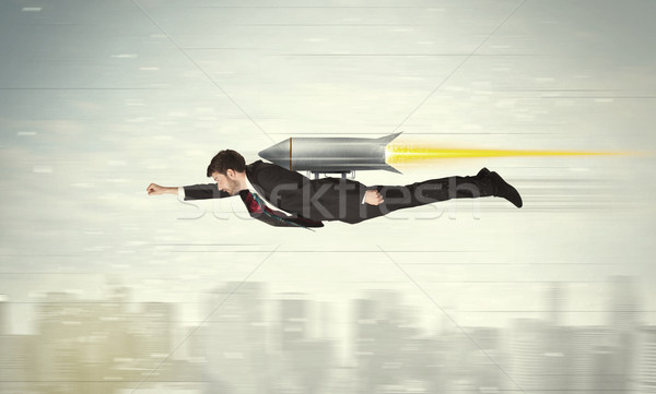 Superhero business man flying with jet pack rocket above the cit Stock photo © ra2studio