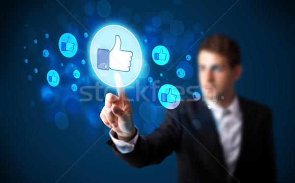 Handsome person pressing thumbs up button on modern social netwo Stock photo © ra2studio
