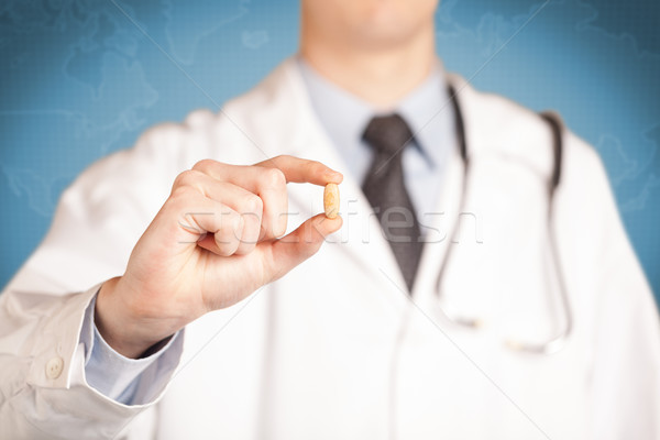 Doctor in white holding a pill Stock photo © ra2studio