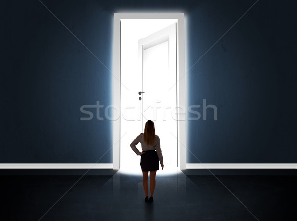 Business woman looking at big bright opened door Stock photo © ra2studio