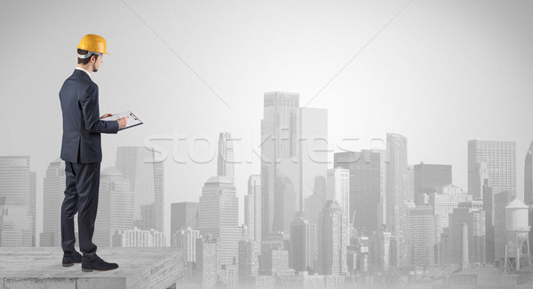 Architect standing on top of a maze and holding a plan Stock photo © ra2studio