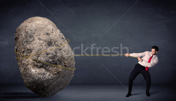 Businessman pulling huge rock with a rope  Stock photo © ra2studio