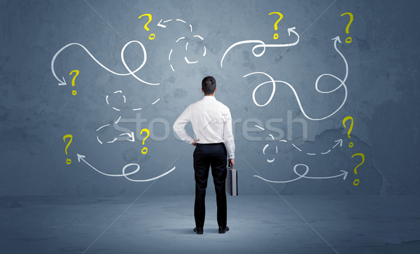 Unsure businessman with question marks Stock photo © ra2studio