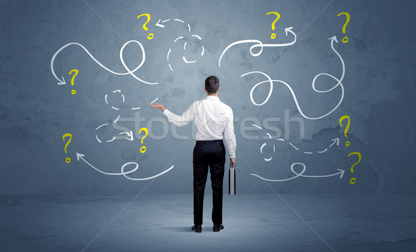 Unsure businessman with question marks Stock photo © ra2studio