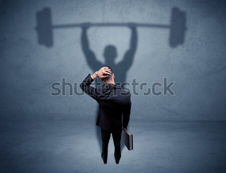 Businessman with weight lifting shadow Stock photo © ra2studio