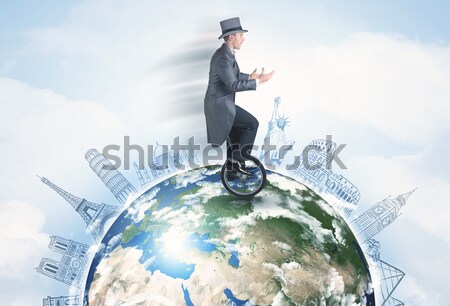 Man riding unicycle around the globe with major cities Stock photo © ra2studio