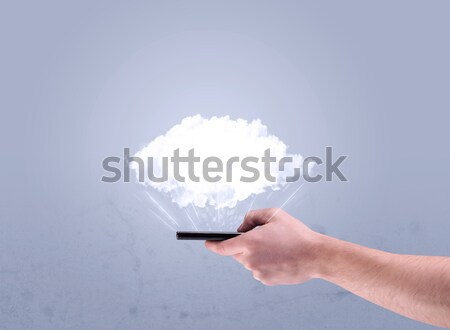 Hand holding phone with empty cloud Stock photo © ra2studio