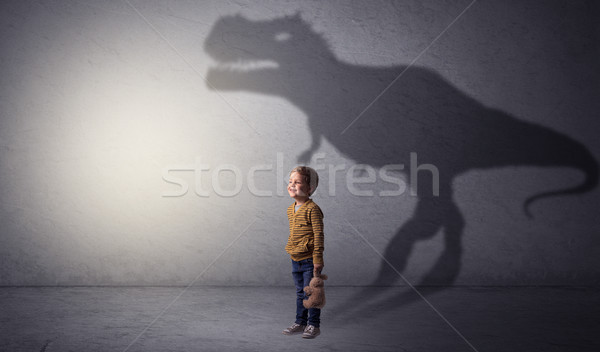 Dinosaurus shadow behind cute boy Stock photo © ra2studio