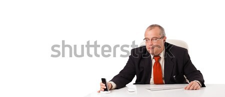 businessman sitting at desk and looking mobilephone with copyspace, isolated on white Stock photo © ra2studio