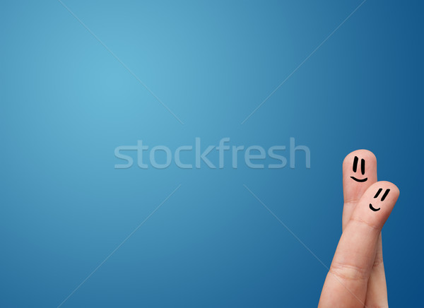 Happy smiley face fingers cheerfully looking at empty blue background copy space Stock photo © ra2studio