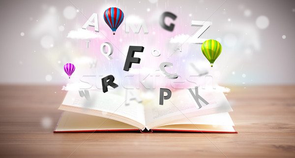 Open book with flying 3d letters on concrete background Stock photo © ra2studio