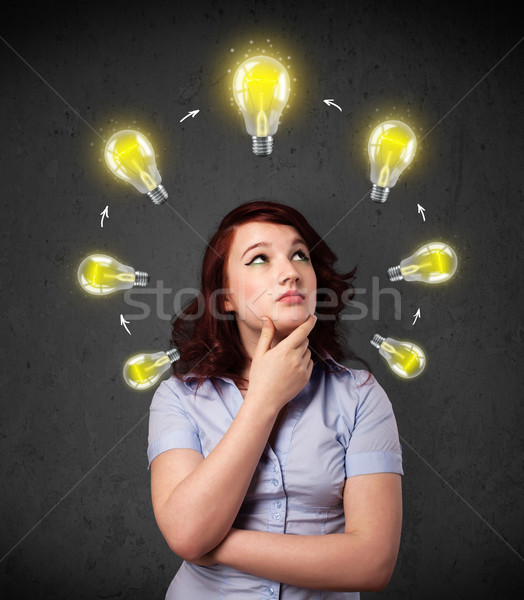 Young woman thinking with lightbulb circulation around her head Stock photo © ra2studio