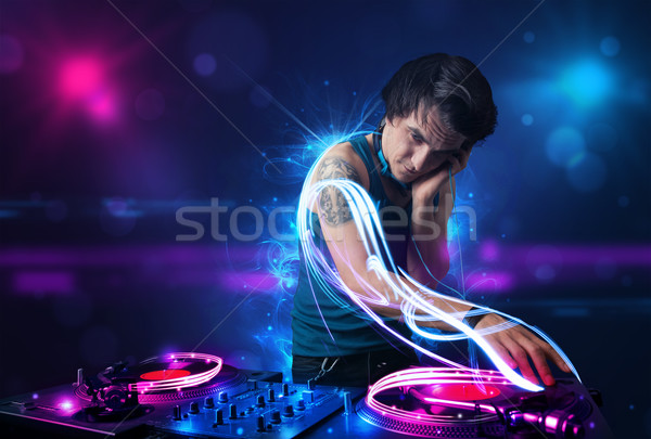 Disc jockey playing music with electro light effects and lights Stock photo © ra2studio