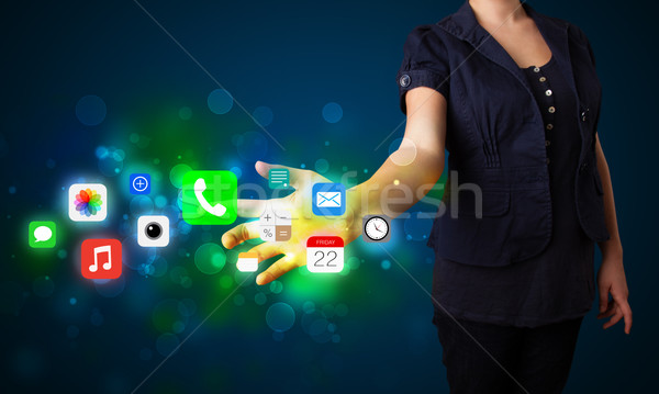 Young businesswoman pressing colorful mobile app icons with boke Stock photo © ra2studio