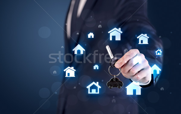 Businessman holding keys with houses around Stock photo © ra2studio