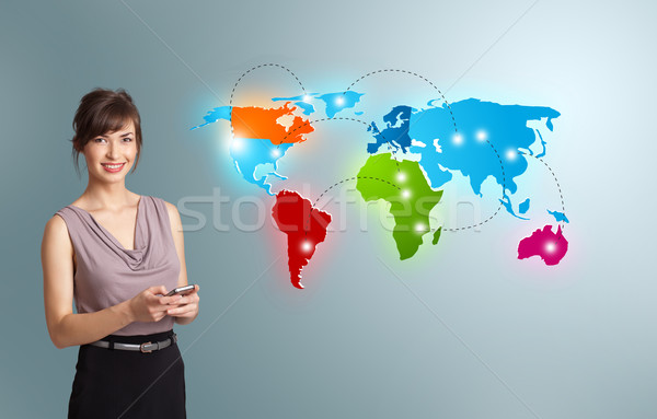 Young woman holding a phone and presenting colorful world map Stock photo © ra2studio
