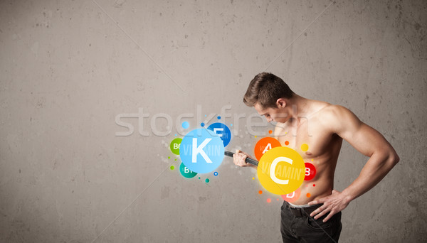 muscular man lifting colorful vitamin weights Stock photo © ra2studio
