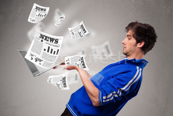 Young man holding a laptop and reading the explosive news Stock photo © ra2studio