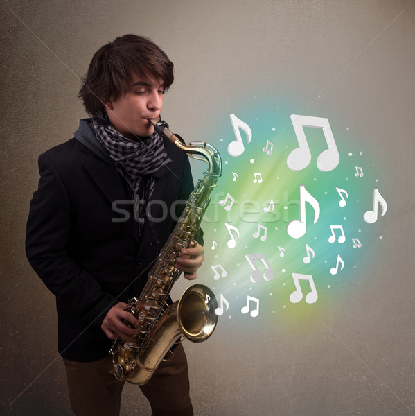 Jóvenes músico jugando saxófono notas musicales atractivo Foto stock © ra2studio