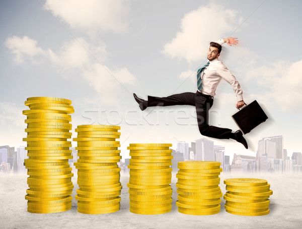 Bem sucedido homem de negócios saltando para cima moeda de ouro dinheiro Foto stock © ra2studio