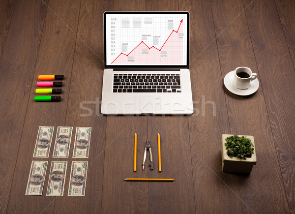 Computer desk with laptop and red arrow chart in screen Stock photo © ra2studio