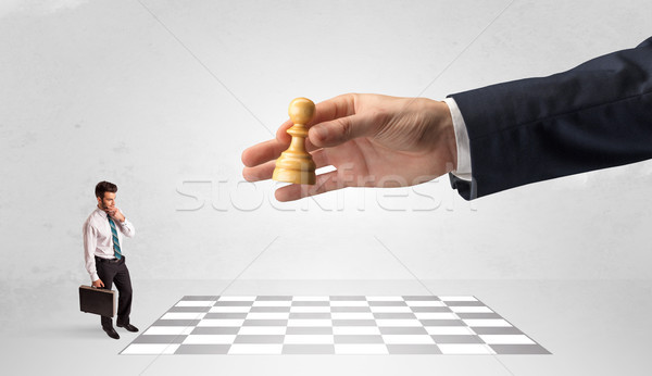 Stock photo: Little businessman playing chess with a big hand concept