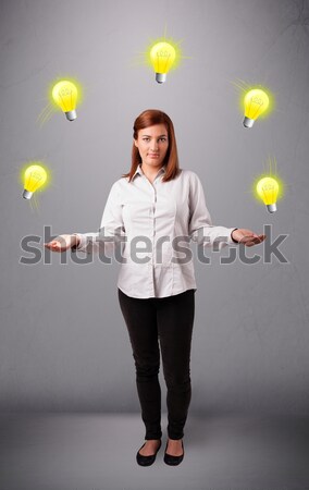 young lady standing and juggling with light bulbs Stock photo © ra2studio