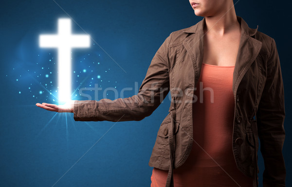 Stock photo: Glowing cross in the hand of a woman