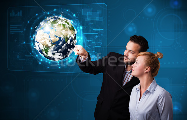 Young couple touching high-tech 3d earth panel Stock photo © ra2studio