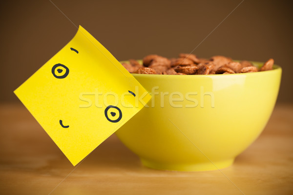 Stock photo: Post-it note with smiley face sticked on a cereal bowl