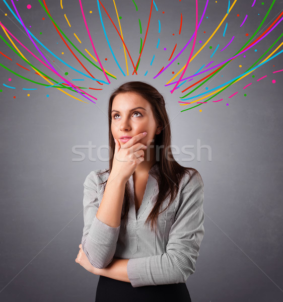 Young girl thinking with colorful abstract lines overhead Stock photo © ra2studio