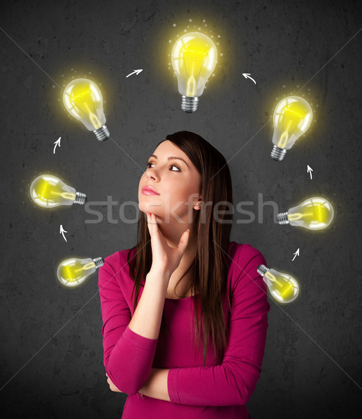 Young woman thinking with lightbulb circulation around her head Stock photo © ra2studio