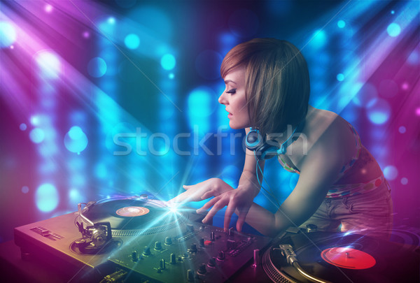 Dj girl mixing music in a club with blue and purple lights Stock photo © ra2studio