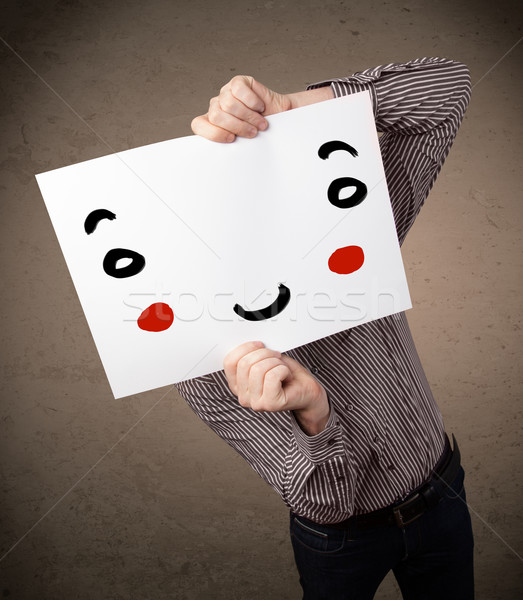 Businessman holding a cardboard with a smiley face on it Stock photo © ra2studio