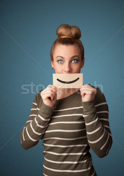 Happy pretty woman holding card with funny smiley Stock photo © ra2studio