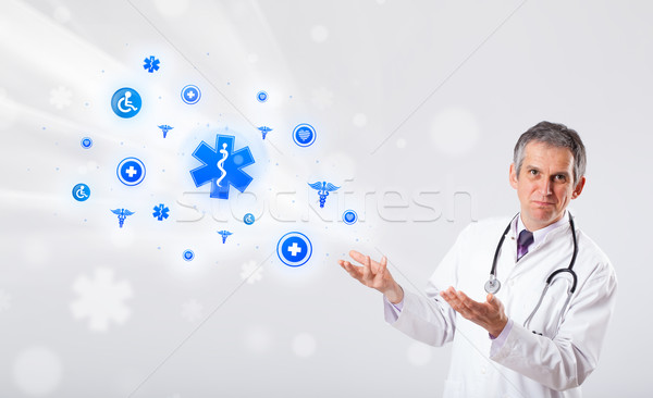 Doctor with blue medical icons Stock photo © ra2studio