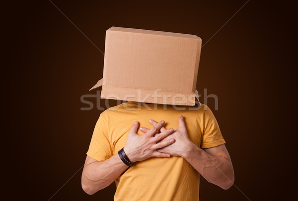 Young man gesturing with a cardboard box on his head Stock photo © ra2studio