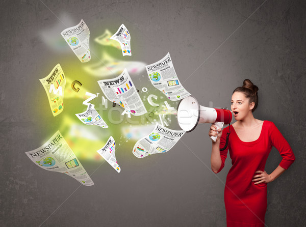 Girl yelling into loudspeaker and newspapers fly out Stock photo © ra2studio