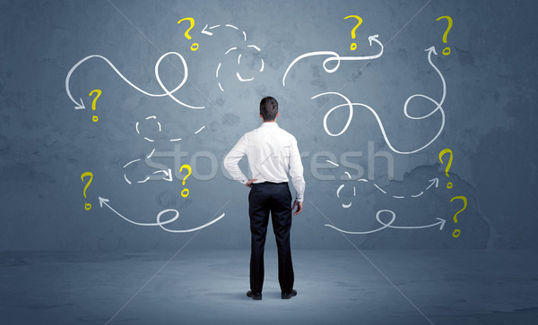 Unsure businessman with question marks Stock photo © ra2studio