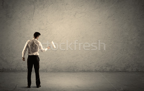 Salesman with roller standing at empty wall Stock photo © ra2studio