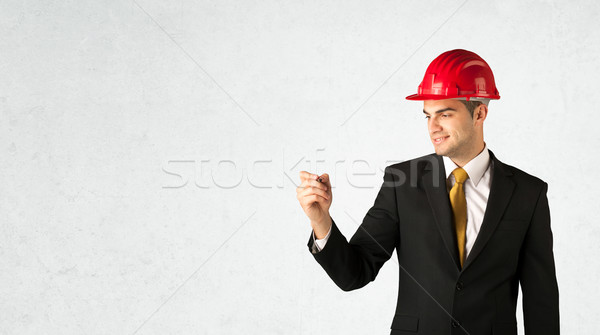 Stock photo: Young architect drawing in empty space