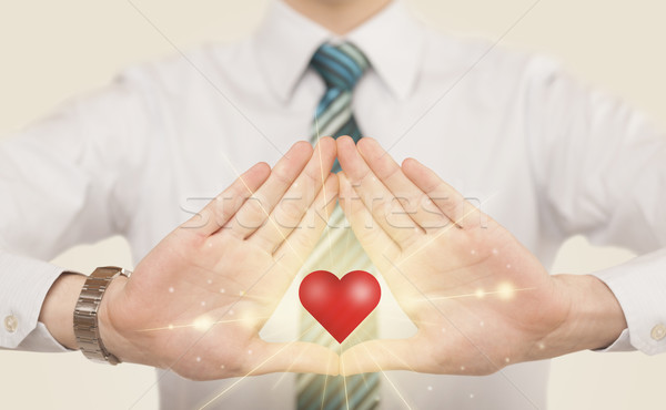 Stock photo: Hands creating a form with shining heart