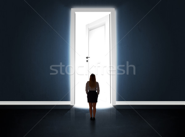 Business woman looking at big bright opened door Stock photo © ra2studio