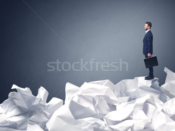 Businessman standing on crumpled paper Stock photo © ra2studio