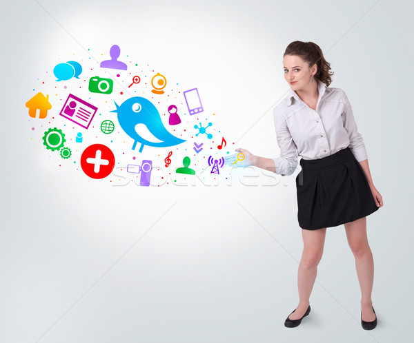 Young business woman presenting colourful social icons Stock photo © ra2studio