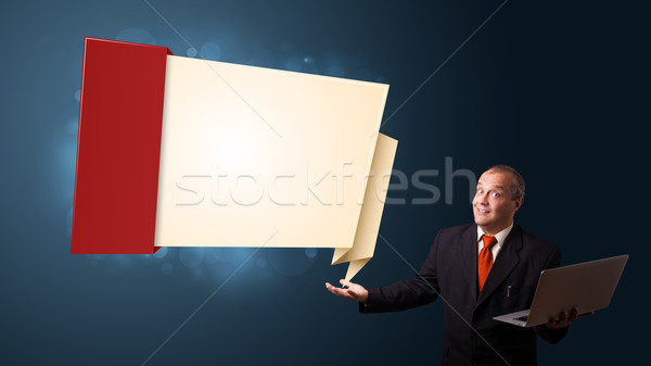 Businessman in suit holding a laptop and presenting modern origami copy space Stock photo © ra2studio