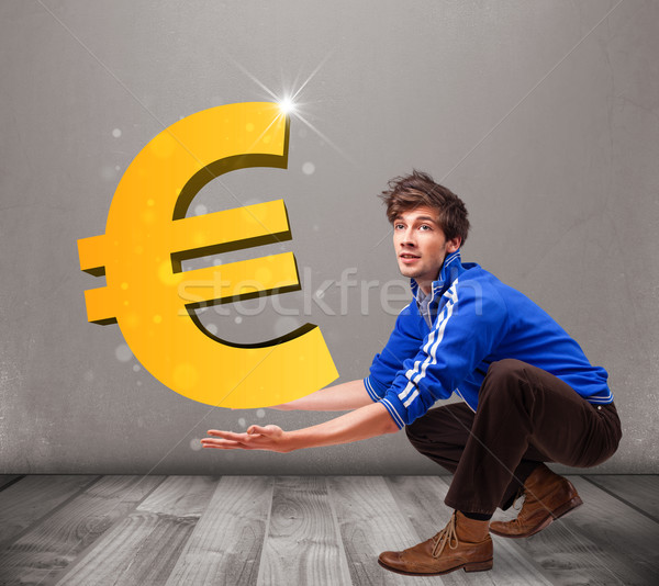 Good-looking boy holding a big 3d gold euro sign Stock photo © ra2studio