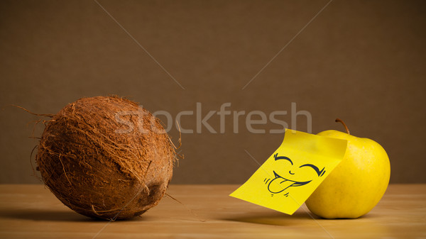 Apple with post-it note sticking out tongue to coconut Stock photo © ra2studio